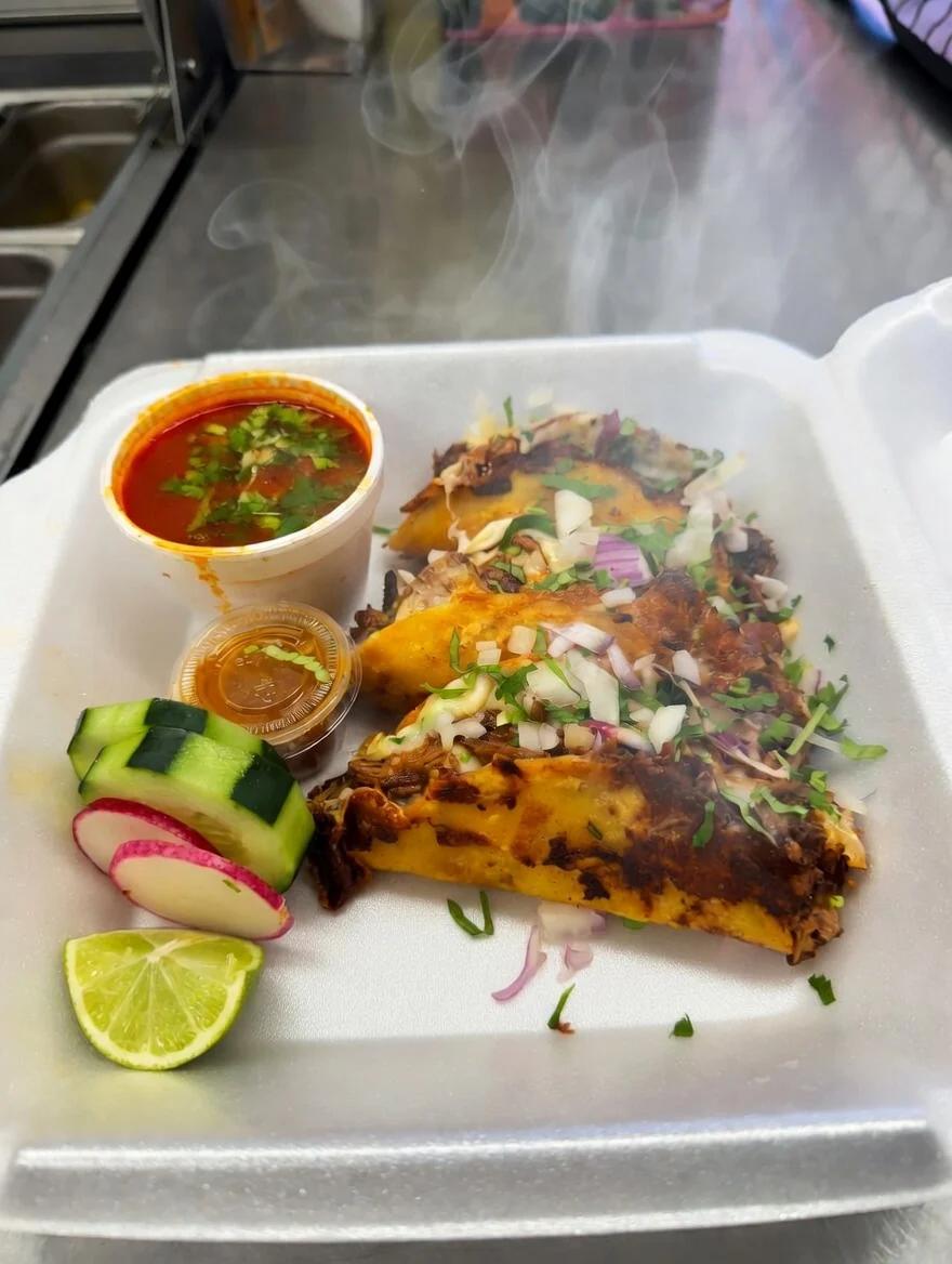 Birria taco with melted cheese, onions, cilantro and consomé — best authentic Mexican tacos in Riviera Beach